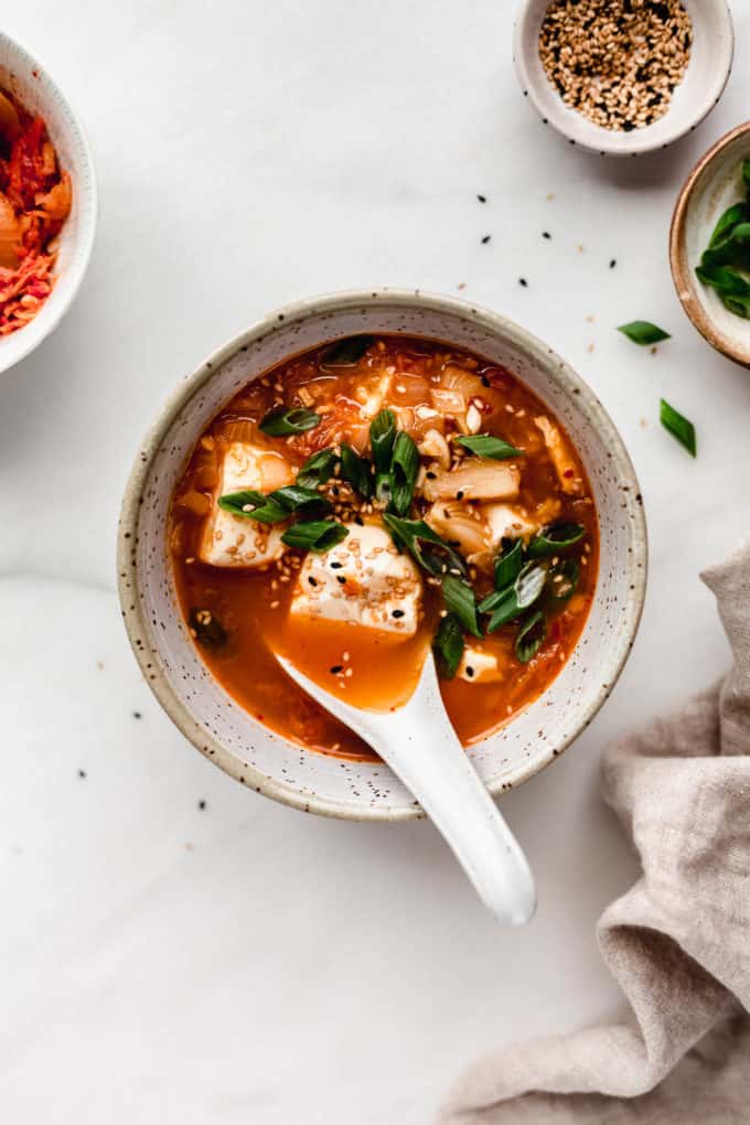 A bowl of korean tofu soup with a spoon in it