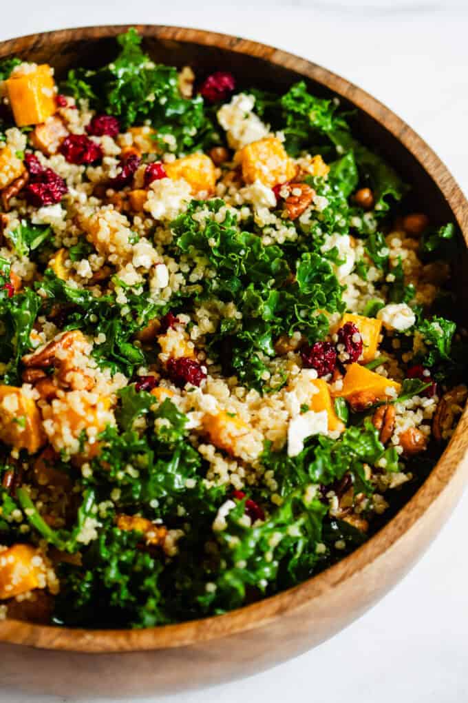 squash, kale and quinoa salad in a wooden bowl