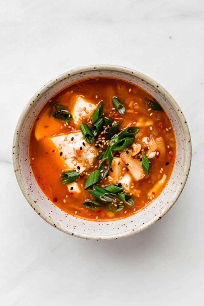 Korean Tofu Soup in a speckled bowl topped with green onions