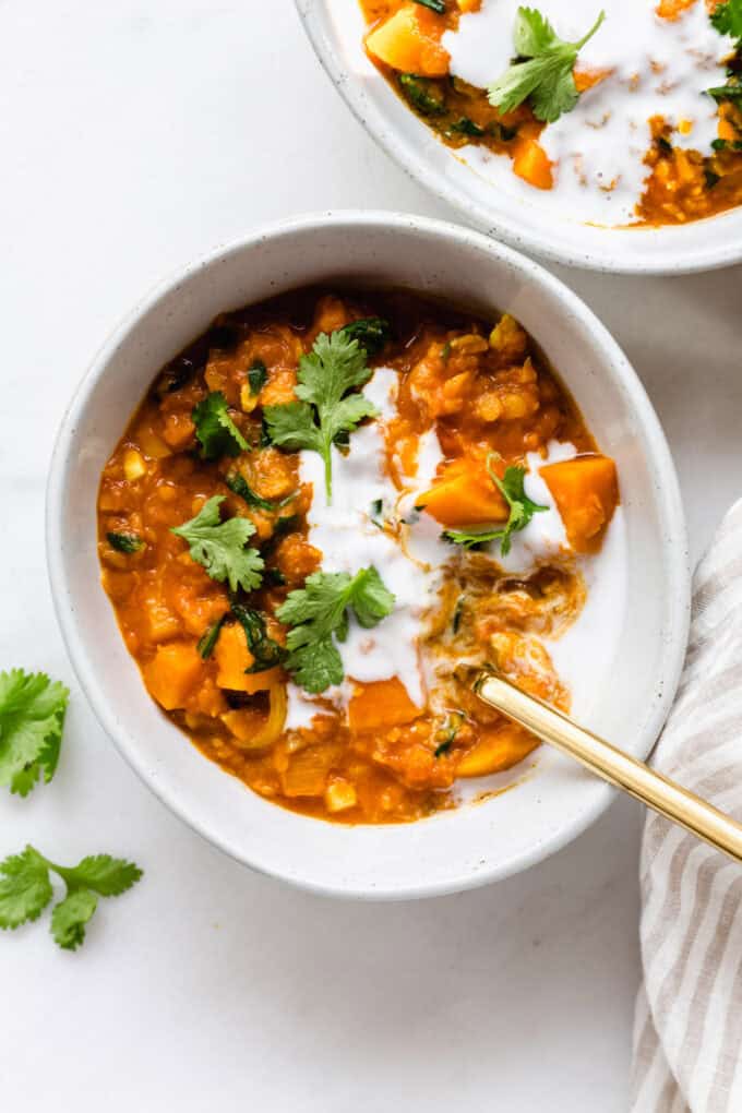 A bowl of sweet potato lentil curry topped with cilantro